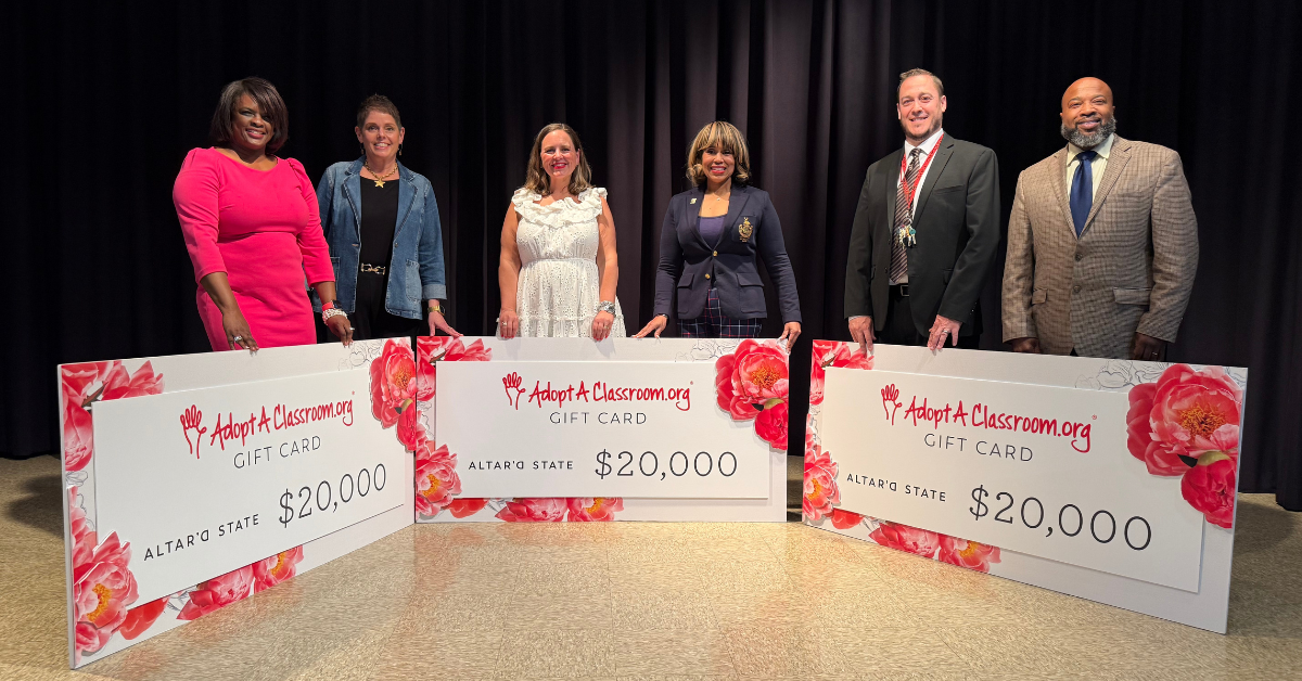 teachers standing with large checks